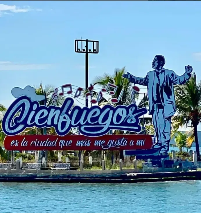 The Cienfuegos sign by the bay, with the figure of Benny Moré singing